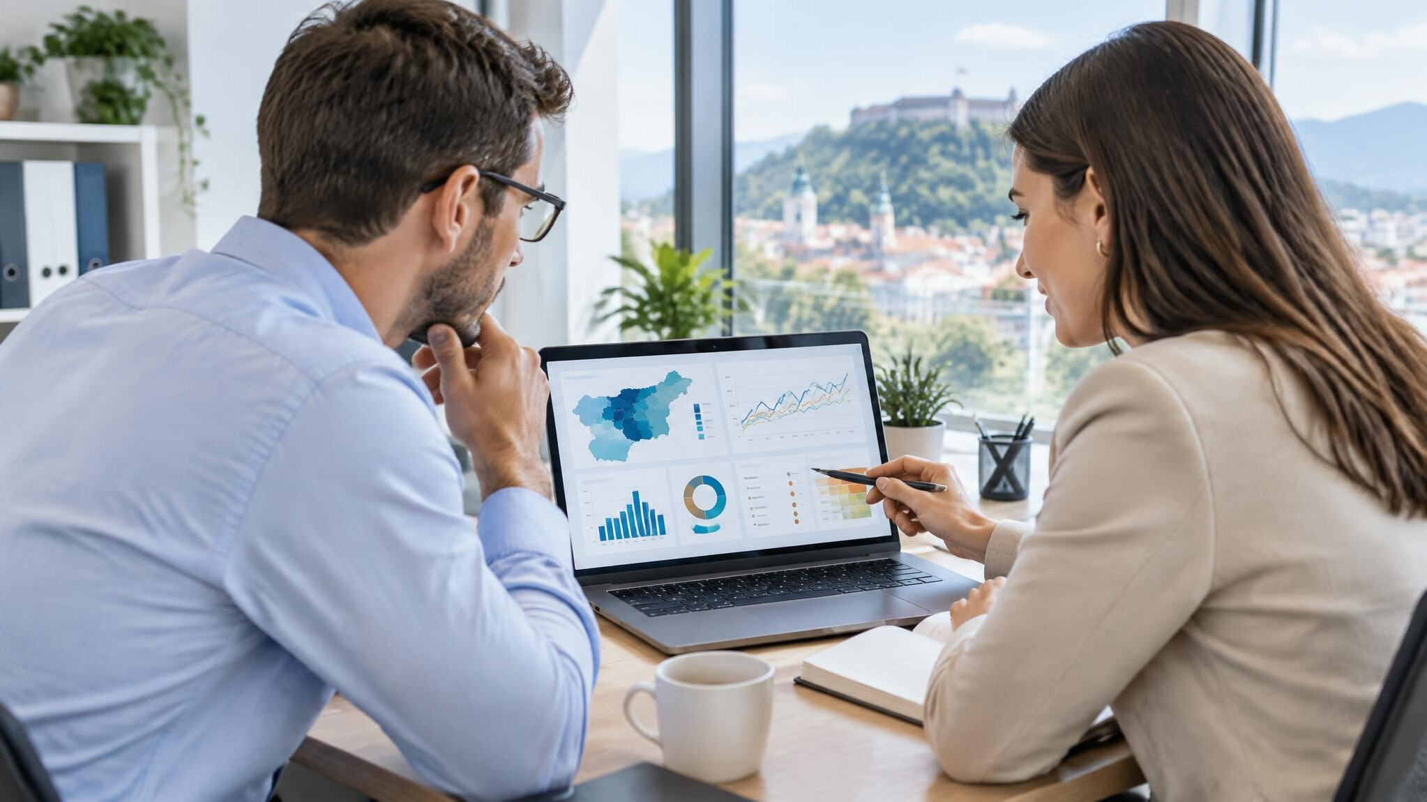 Two colleagues reviewing insurance risk charts on a laptop in an office